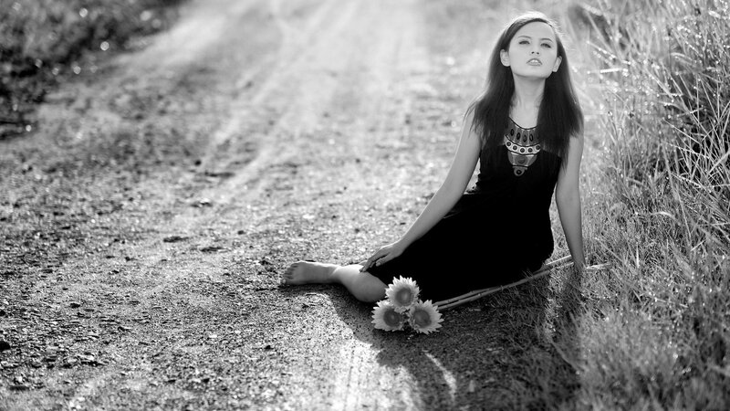 woman sitting on a dirt road
