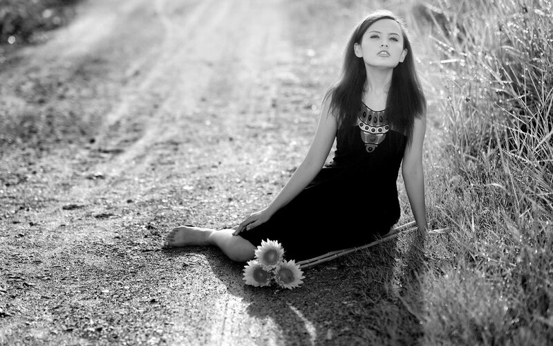 woman sitting on a dirt road