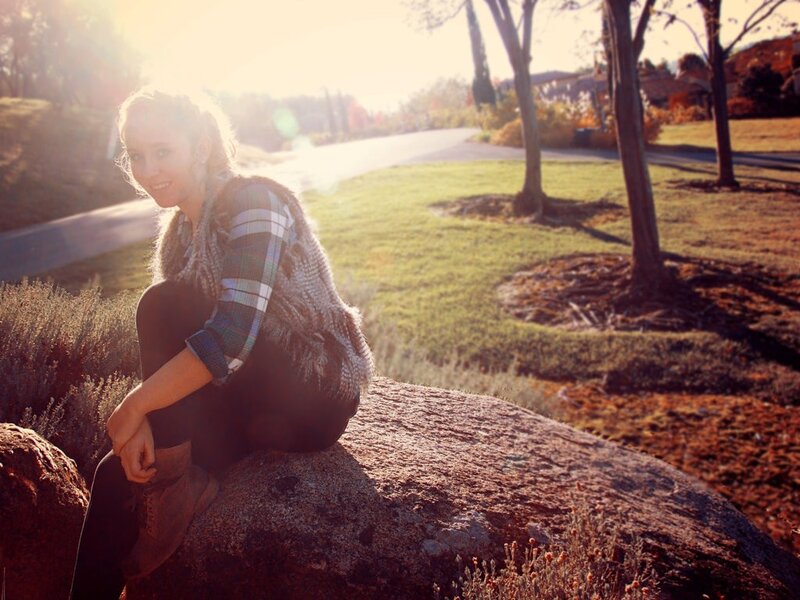 woman sitting on a rock at sunset