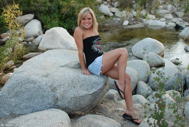 Woman sitting on a rock by a stream