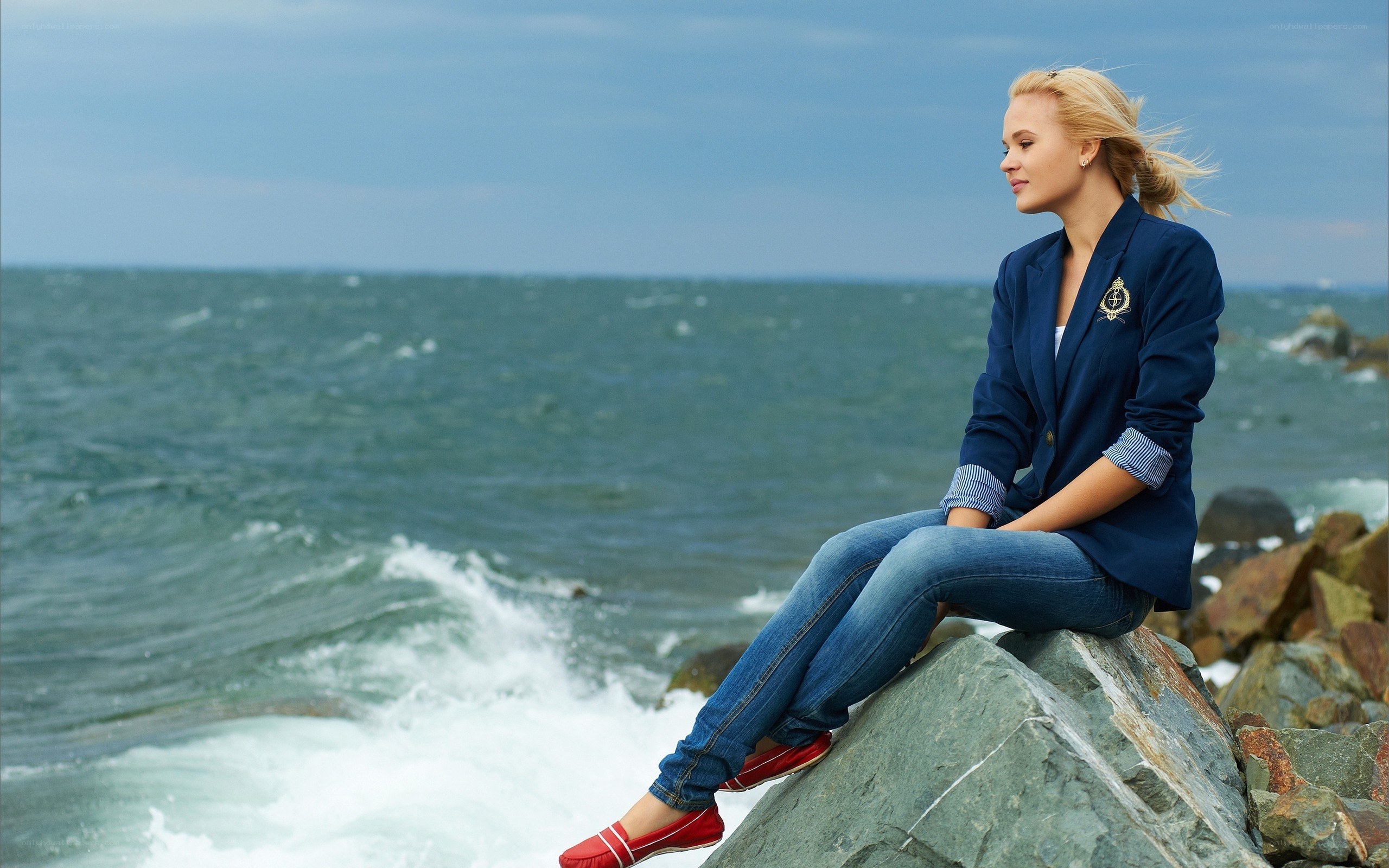 Woman sitting on a rock by the sea