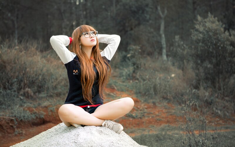 woman sitting on a rock outdoors