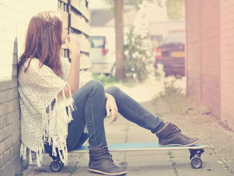 woman sitting on a skateboard