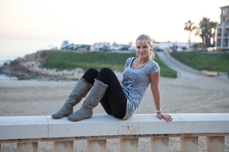 woman sitting on a wall at the beach