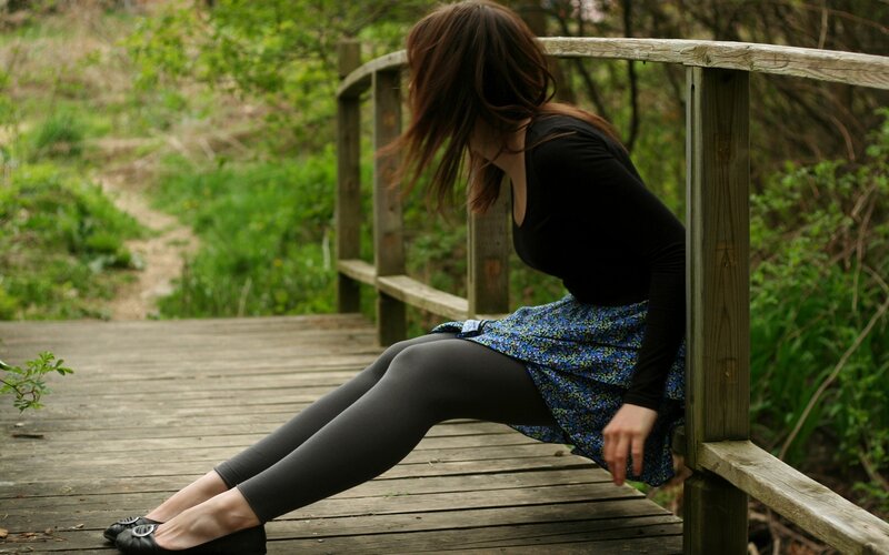Woman sitting on a wooden bridge