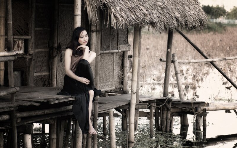 woman sitting on bamboo dock