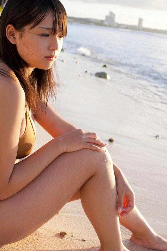 woman sitting on beach at sunset
