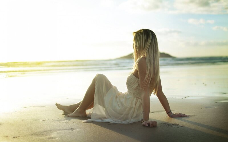 Woman Sitting on Beach — Beige, Serene, Sunset