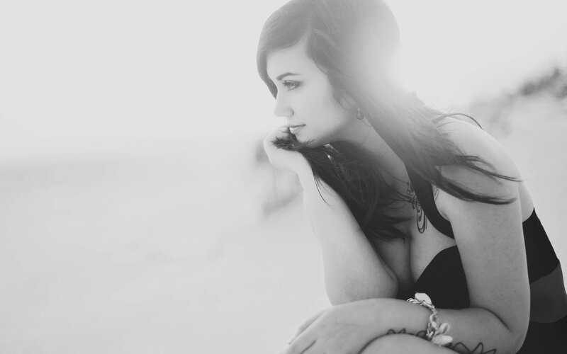 Woman Sitting on Beach — Black, Contemplative, Sunset