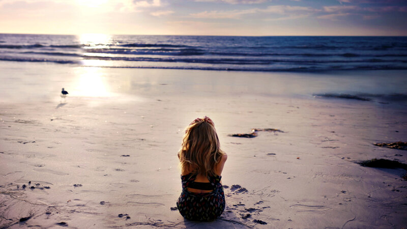 Woman Sitting on Beach — Blue, Serene, Sunset