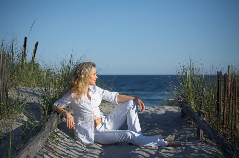 Woman sitting on beach dune