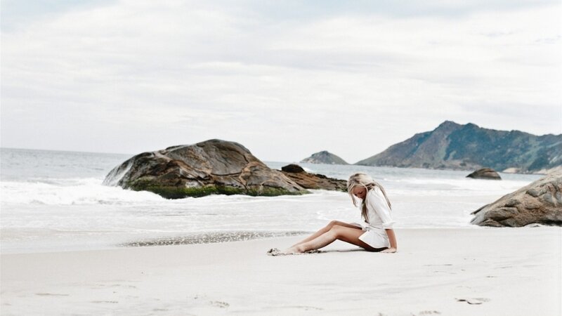 Woman Sitting on Beach — White, Calm