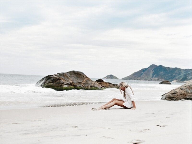 Woman Sitting on Beach — White