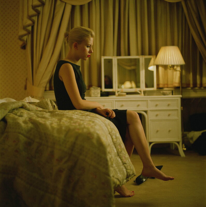 woman sitting on bed in bedroom