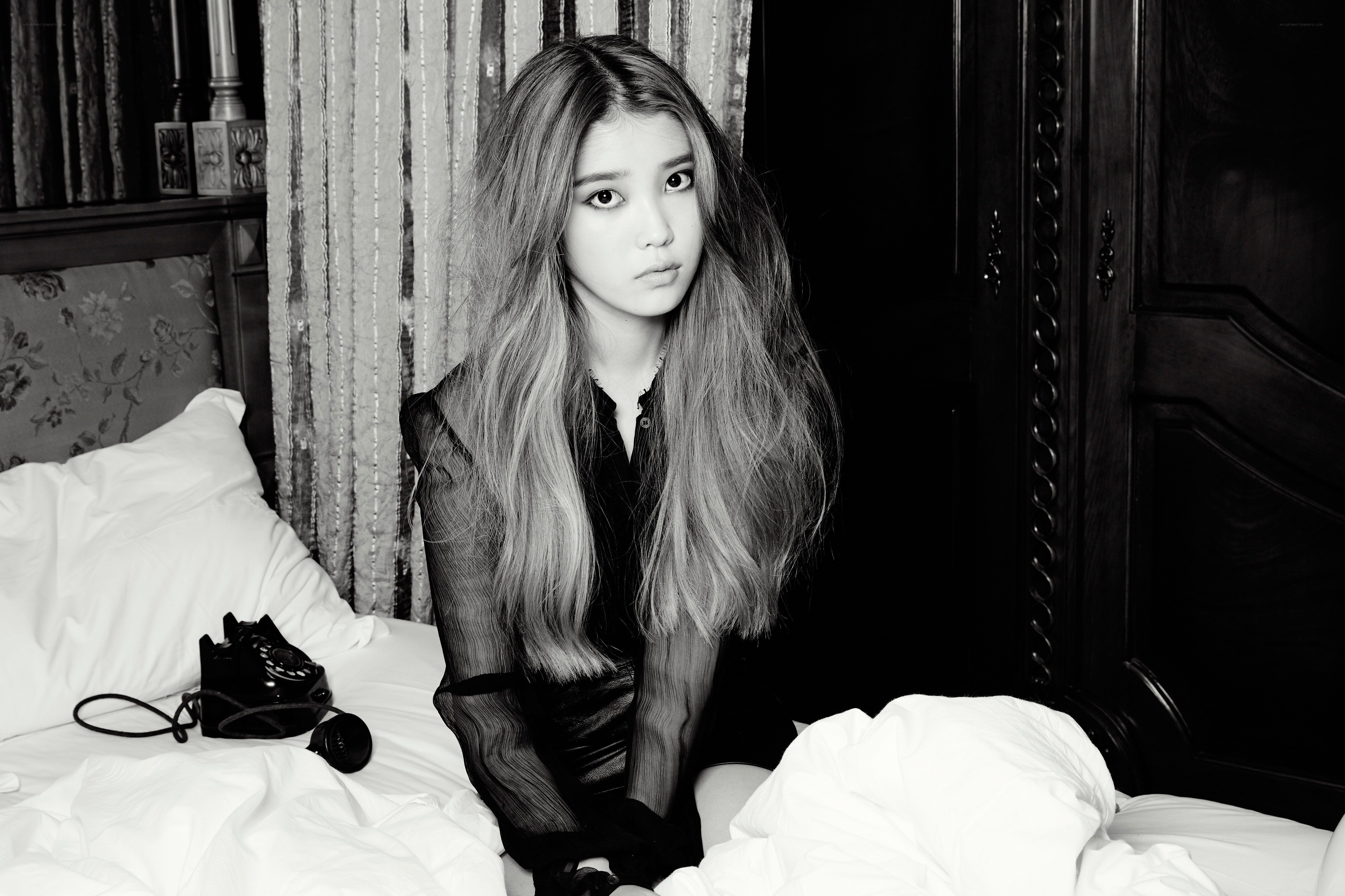 woman sitting on bed in black and white