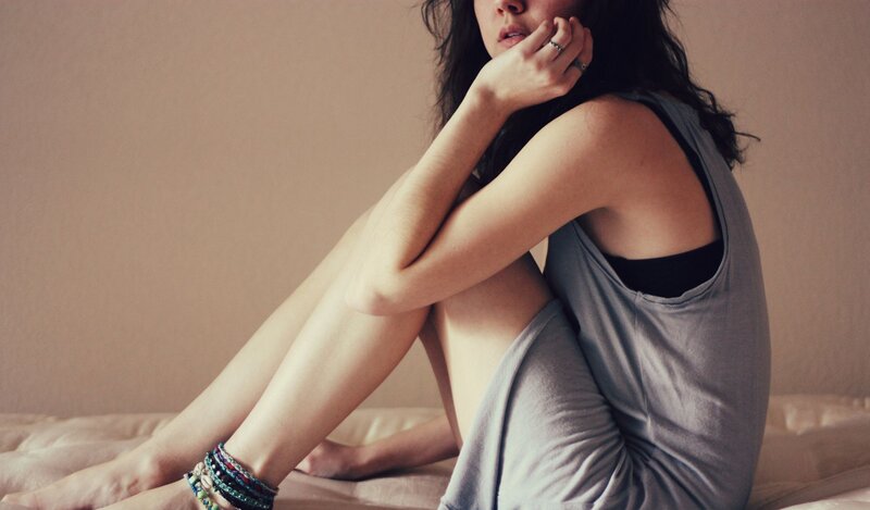 woman sitting on bed in contemplation