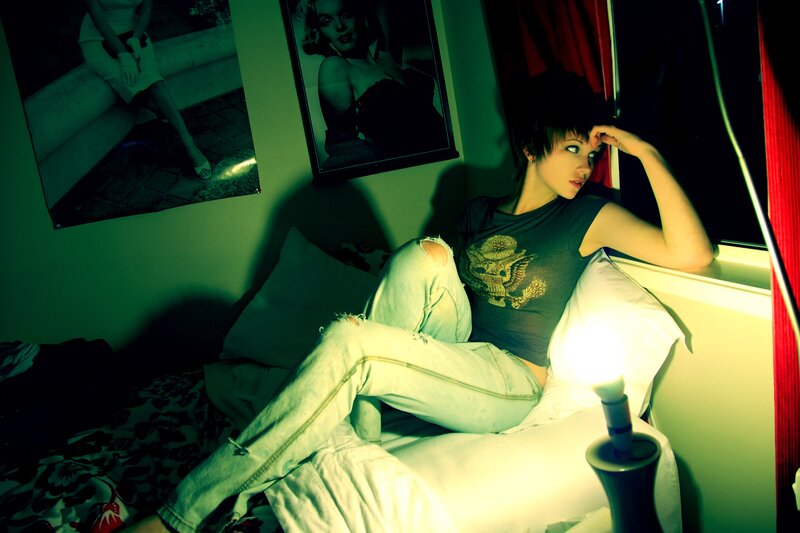 woman sitting on bed in green light