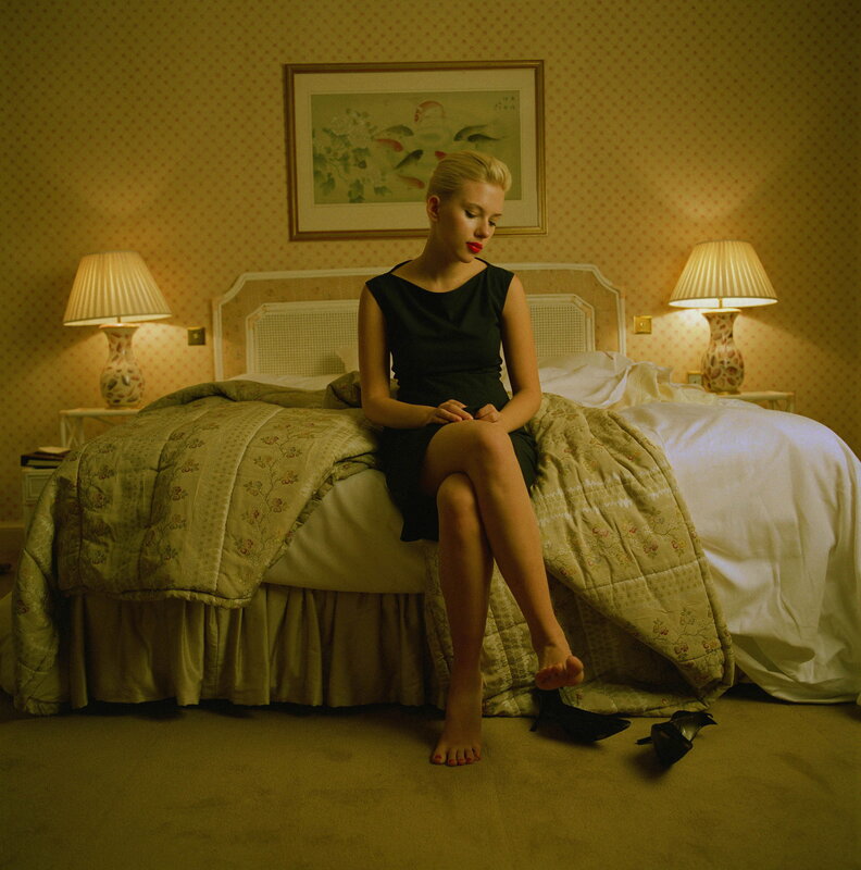 woman sitting on bed in hotel room