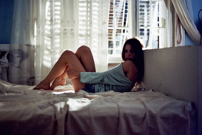 woman sitting on bed in sunlight