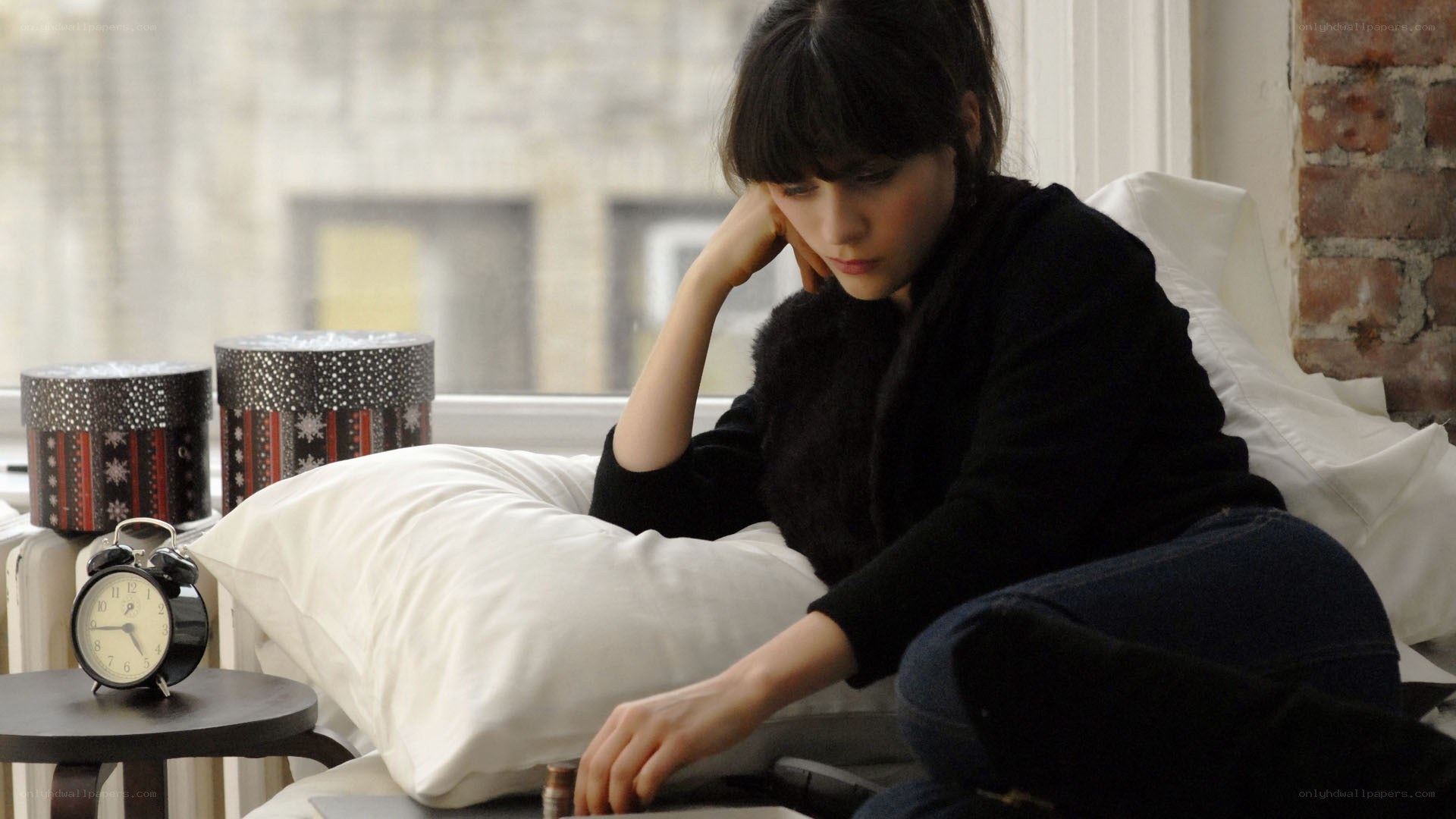 woman sitting on bed looking down