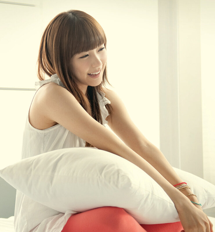 woman sitting on bed with pillow