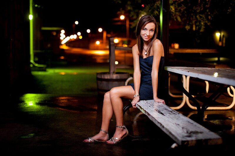Woman sitting on bench at night