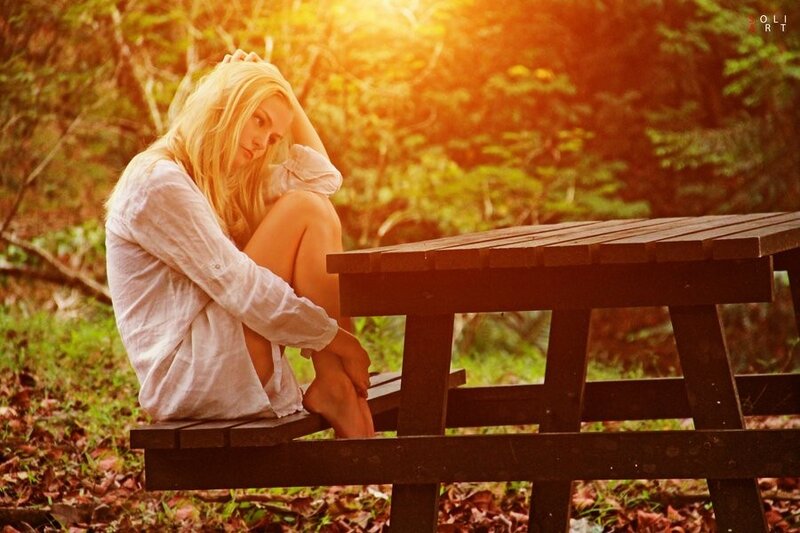 Woman sitting on bench in forest