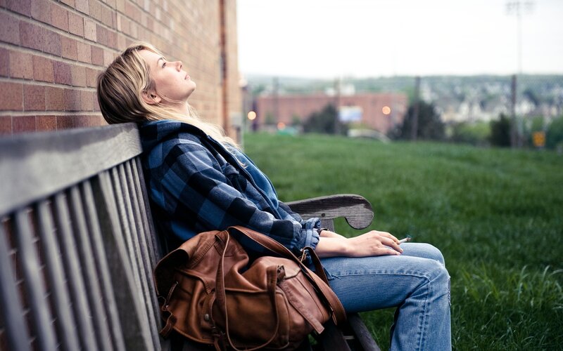 woman sitting on bench smoking
