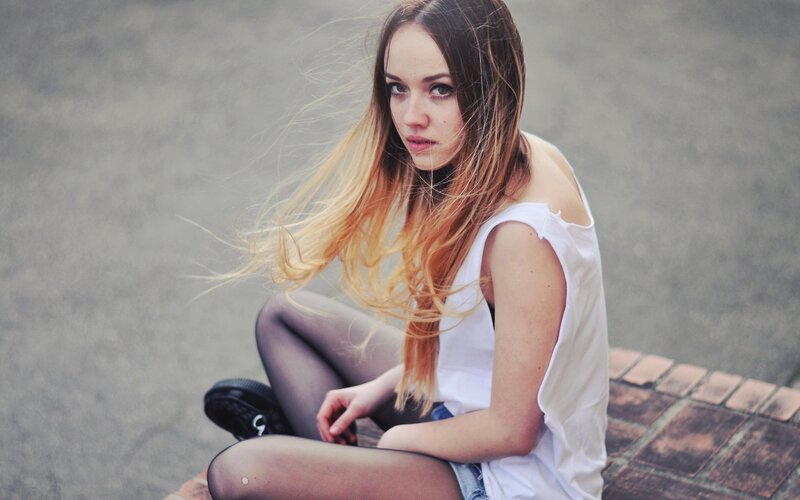 woman sitting on brick ledge