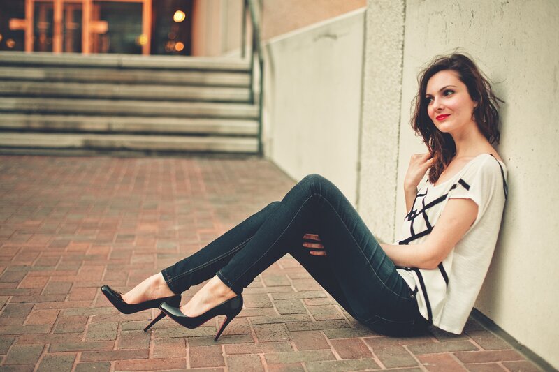 woman sitting on brick pavement