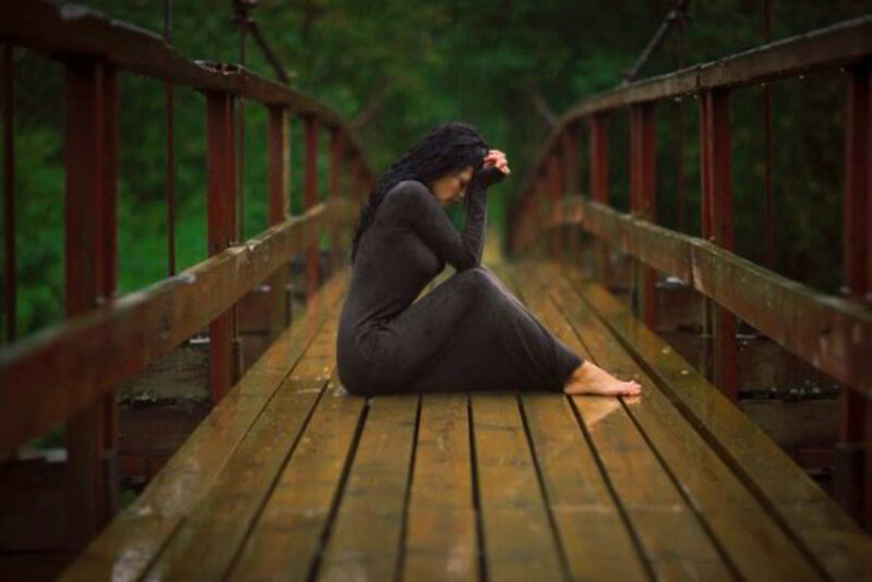 Woman Sitting on Bridge