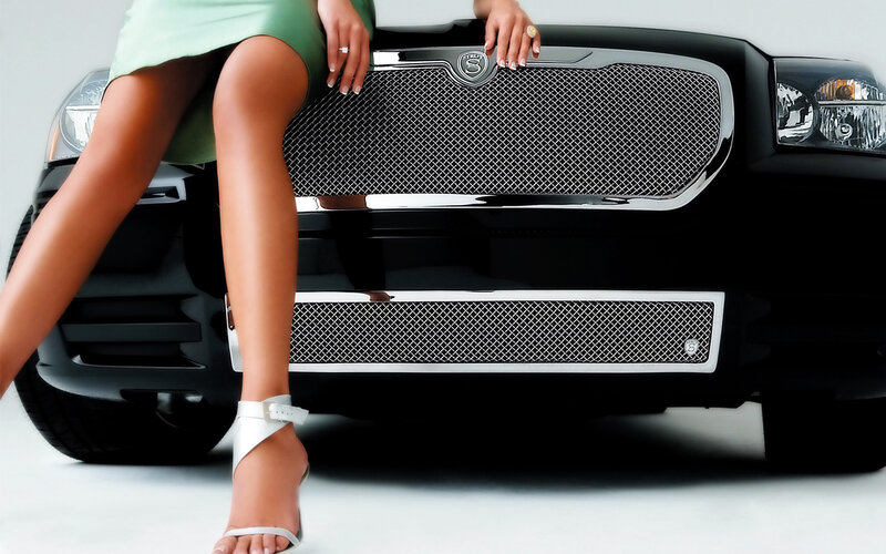 woman sitting on car grille