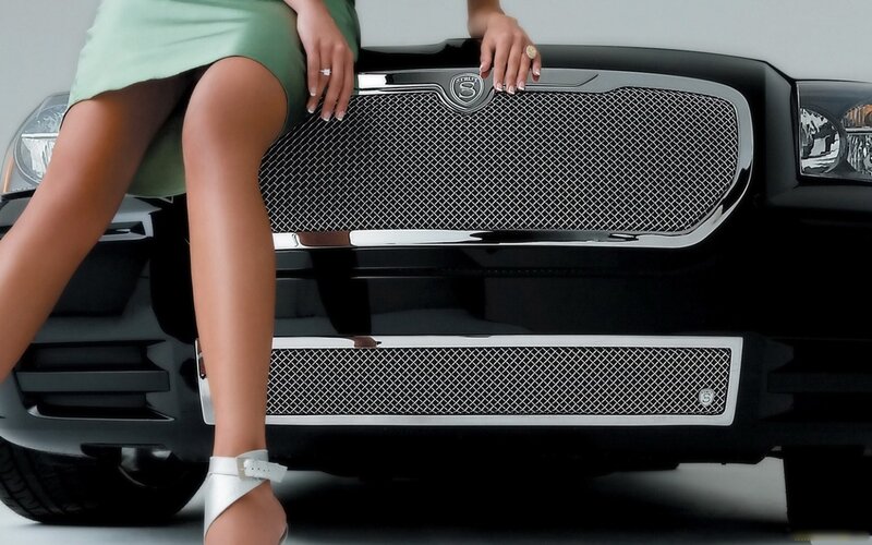 woman sitting on car grille