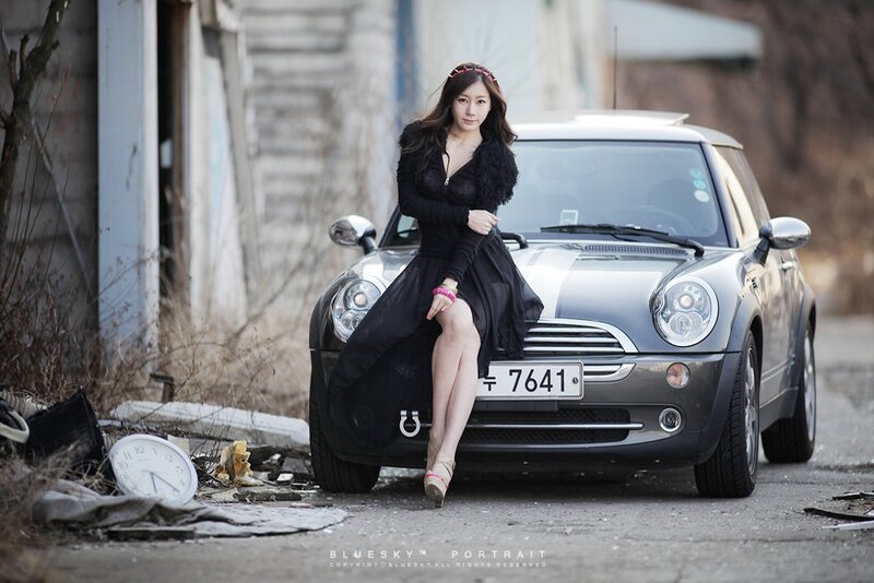 woman sitting on car in urban setting