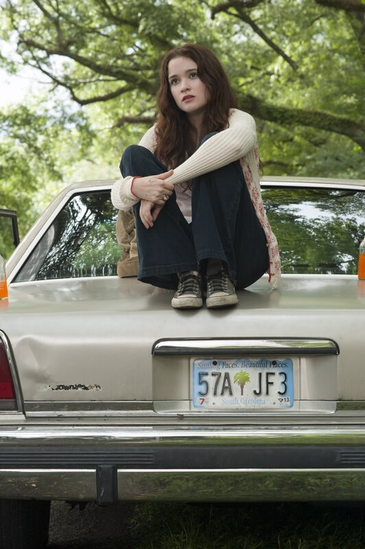 woman sitting on car trunk