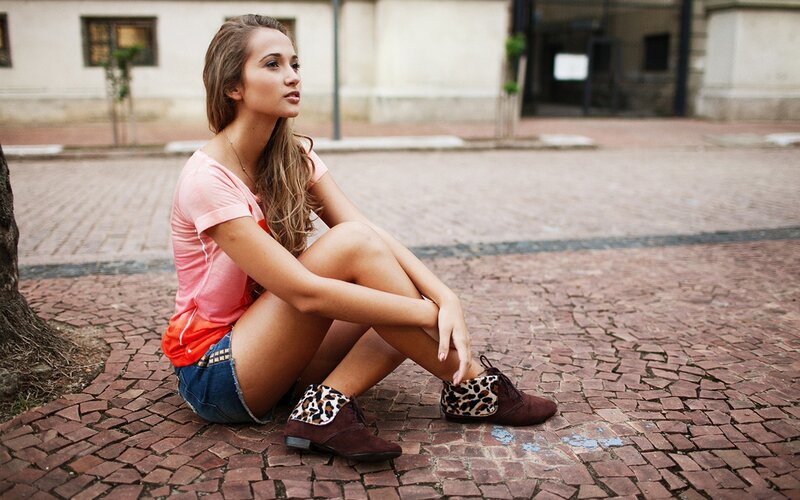 woman sitting on cobblestones