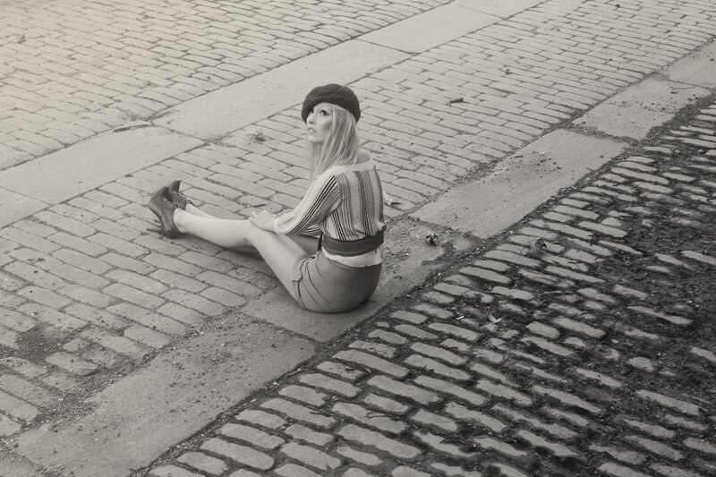 woman sitting on cobblestones