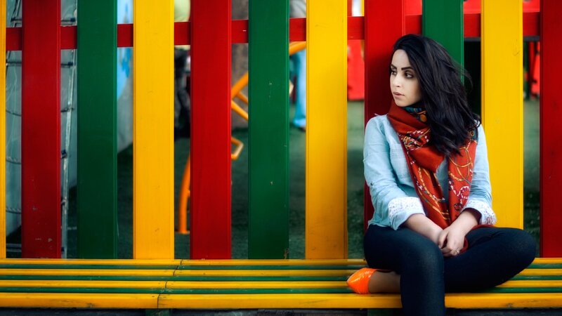 woman sitting on colorful bench