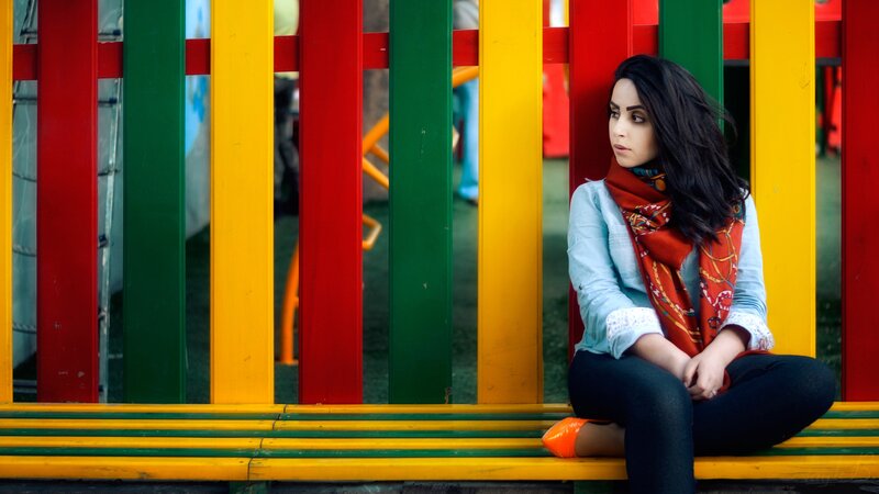 woman sitting on colorful bench