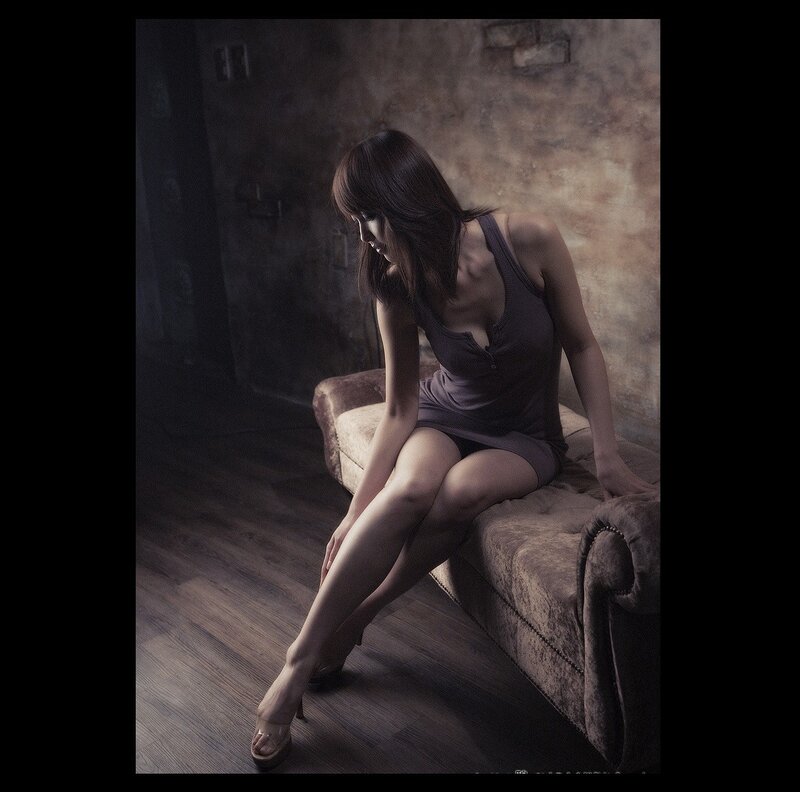 Woman Sitting on Couch — Brown, Dramatic