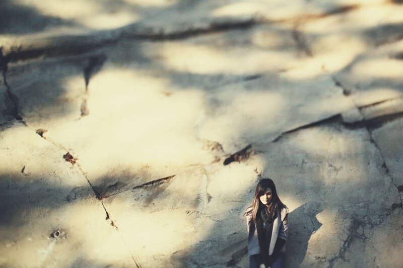 woman sitting on cracked ground