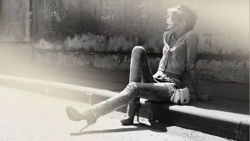 woman sitting on curb in sunlight