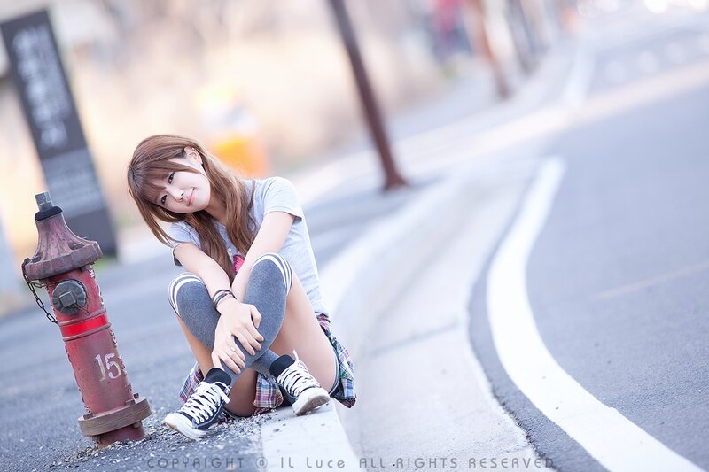 woman sitting on curb near hydrant