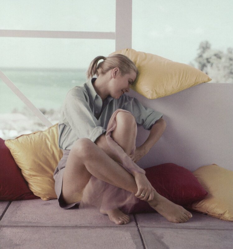 Woman sitting on cushions by window