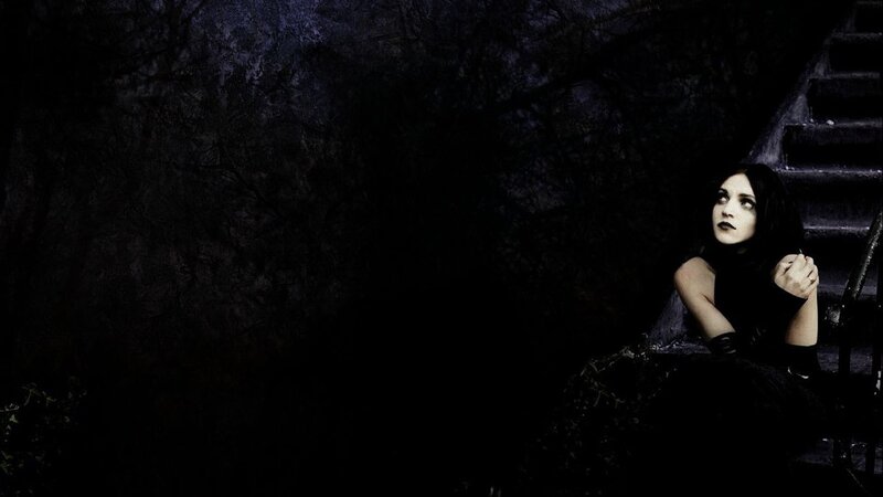 woman sitting on dark stairs