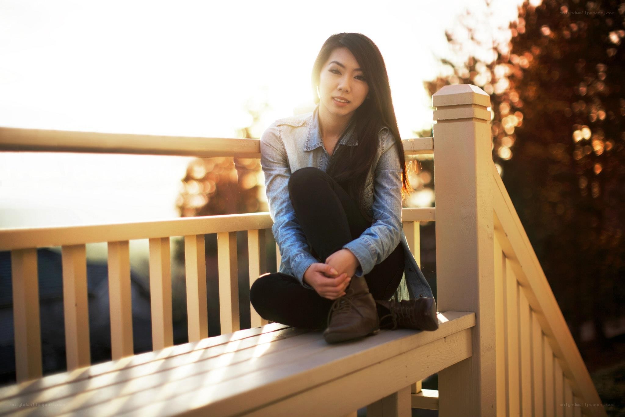 woman sitting on deck at sunset