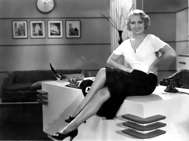 Woman Sitting on Desk — Black, Confident