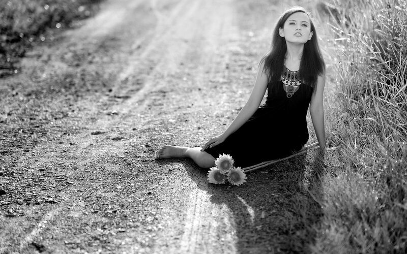 Woman Sitting on Dirt Road