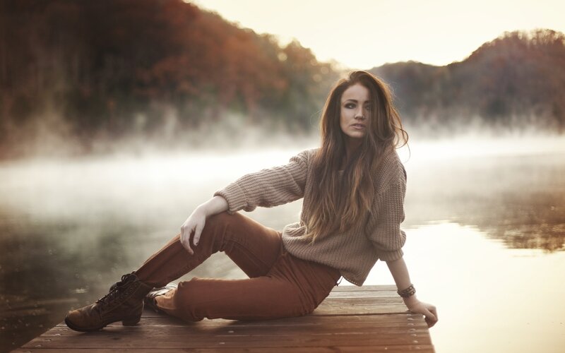 woman sitting on dock at dawn
