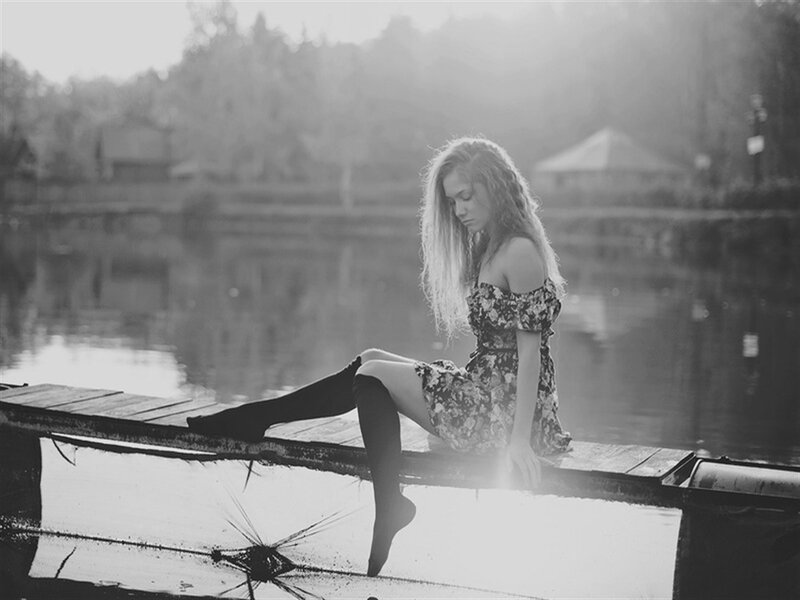 Woman Sitting on Dock — Black, Serene, Sunset